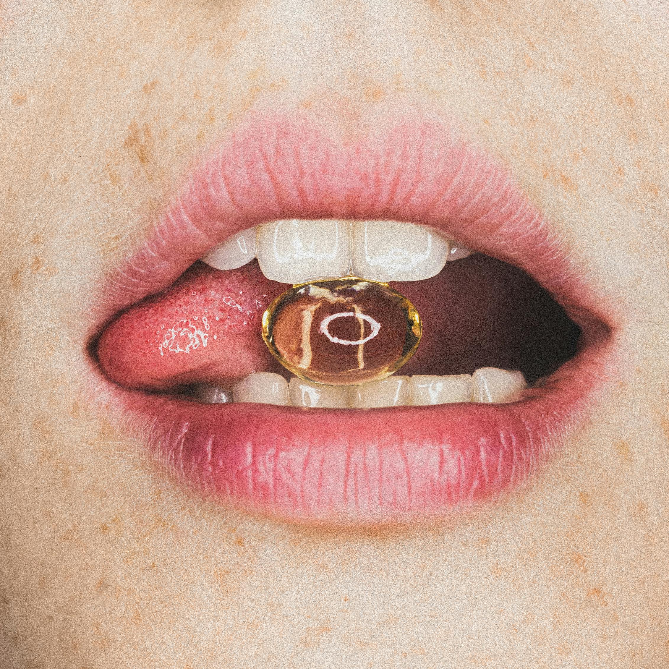 ros plan d’une bouche féminine tenant une capsule dorée entre les dents et la langue. Image